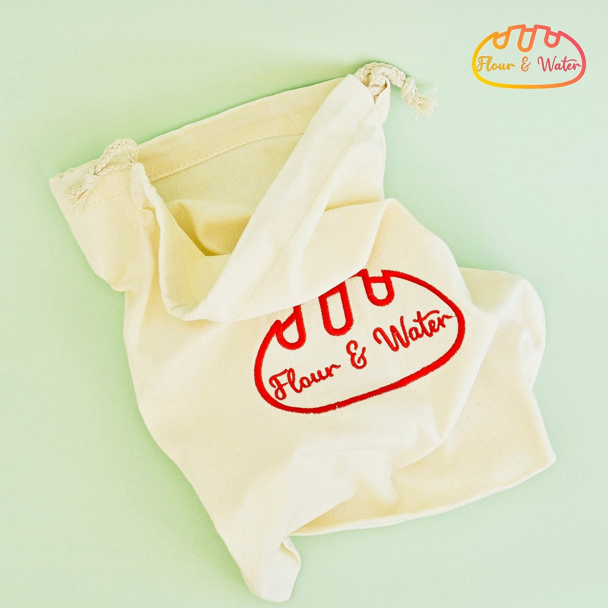 Canvas bread bag lying open on a green background