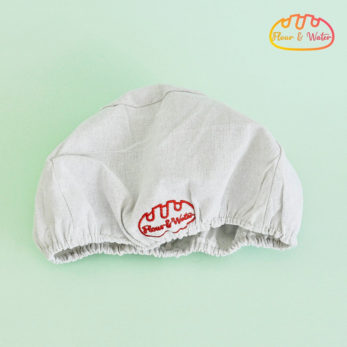 Round cloth banneton liner with elasticated edge and embroidered logo