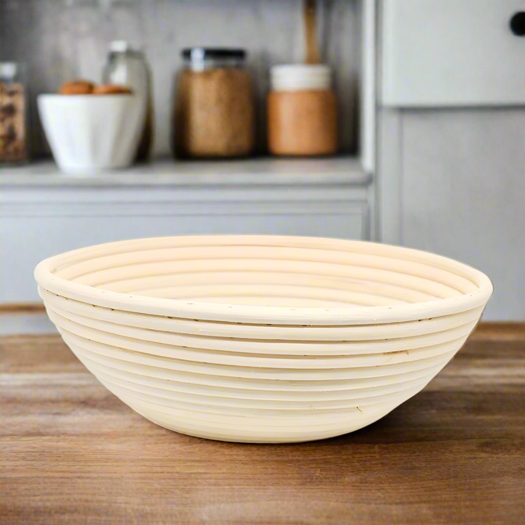Round rattan banneton proofing basket on a wooden kitchen bench