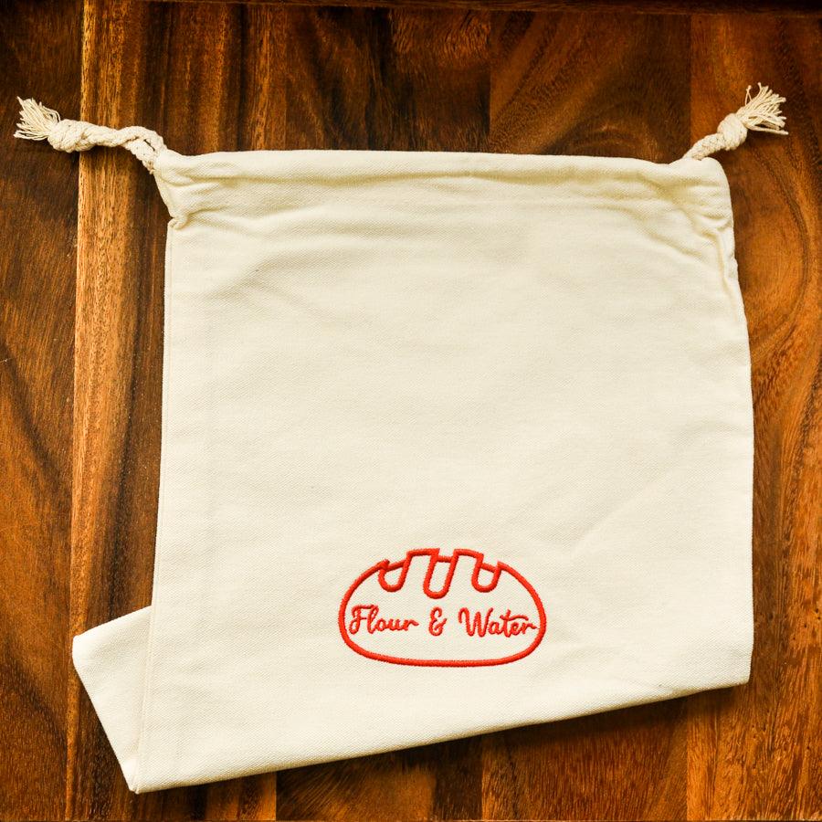 Canvas bread bag laid flat on a wooden table