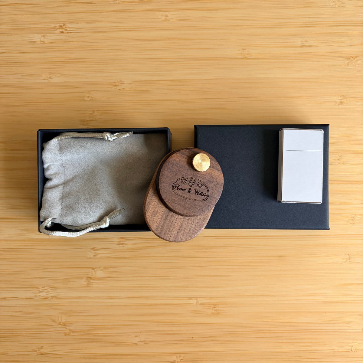 Walnut swivel bread lame closed with blade stored, beside gift box, pouch and blade box