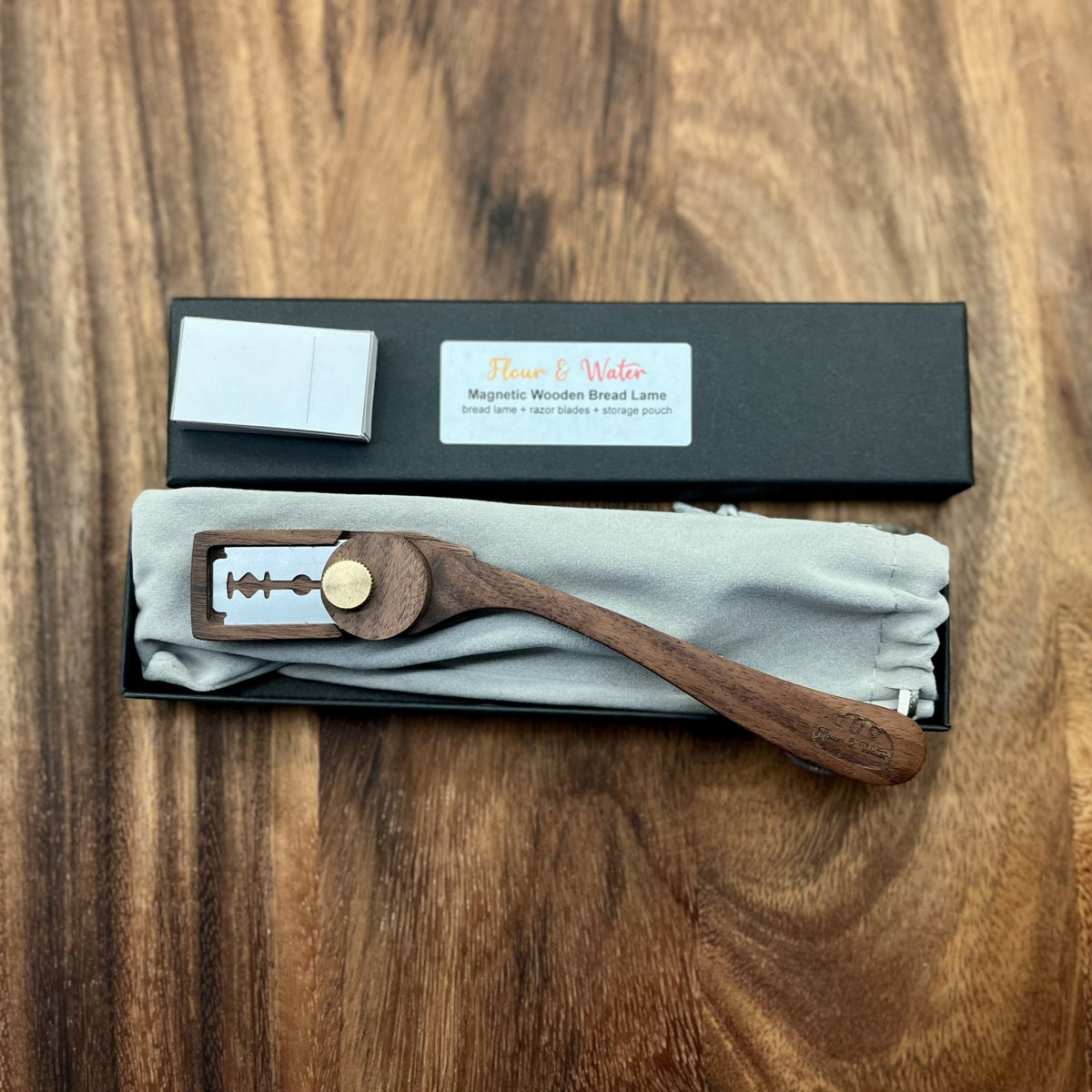 Magnetic wooden bread lame in its gift box, top view with product label