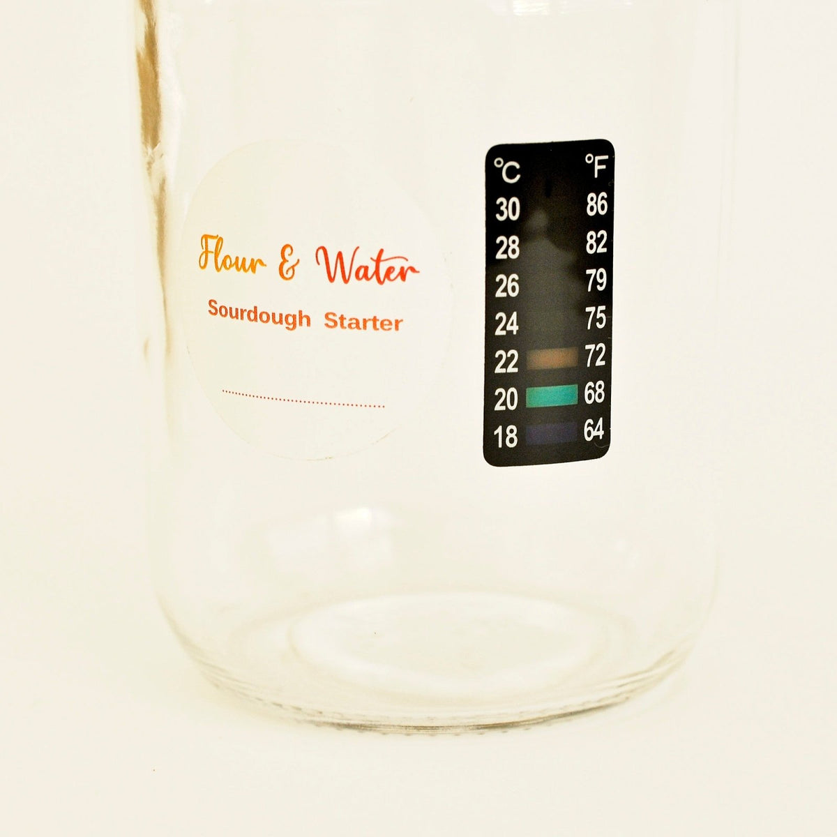 Close-up of the stick-on thermometer on the sourdough starter jar